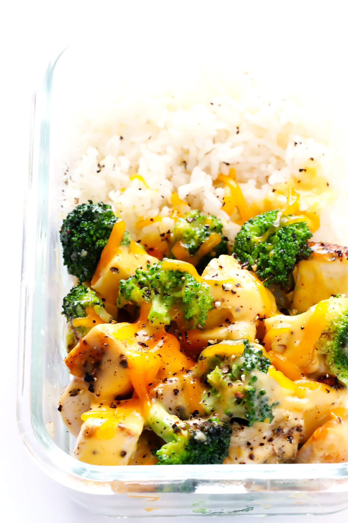 These Cheesy Broccoli, Chicken and Rice Bowls are perfect for easy meal prep or weeknight dinner, they're tossed with a lightened-up garlicky cheddar cheese sauce, and they're totally savory and delicious! Feel free to serve with rice or quinoa. | gimmesomeoven.com