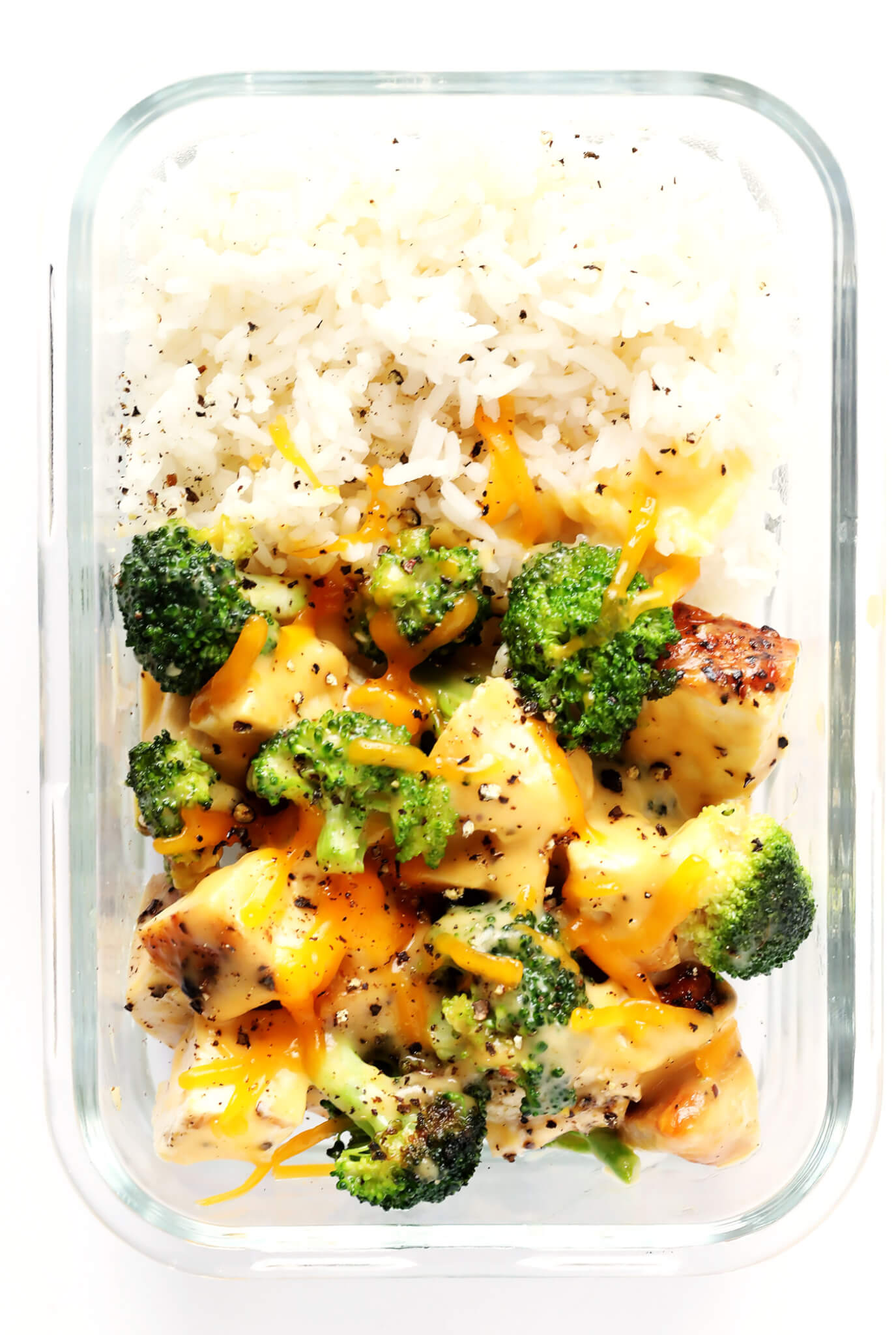 These Cheesy Broccoli, Chicken and Rice Bowls are perfect for easy meal prep or weeknight dinner, they're tossed with a lightened-up garlicky cheddar cheese sauce, and they're totally savory and delicious! Feel free to serve with rice or quinoa. | gimmesomeoven.com