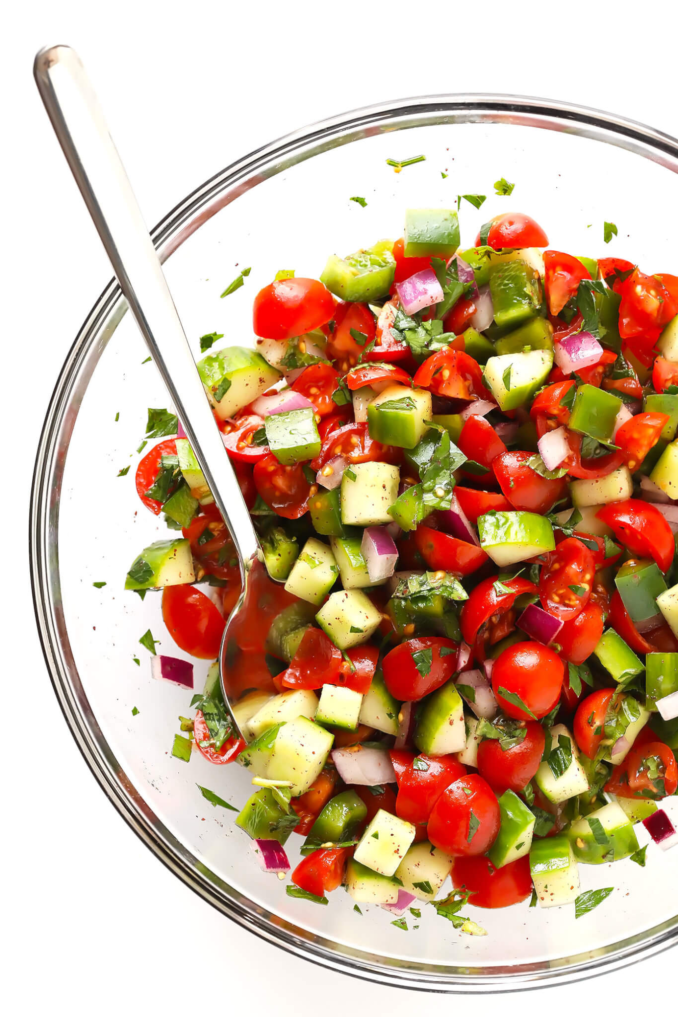 This delicious Israeli Salad recipe is quick and easy to make, full of the fresh flavors of tomatoes, cucumbers, peppers, mint, parsley and sumac, and it's so delicious! Serve it up on its own, or use it to make a simple pita wrap or hummus dip! | gimmesomeoven.com