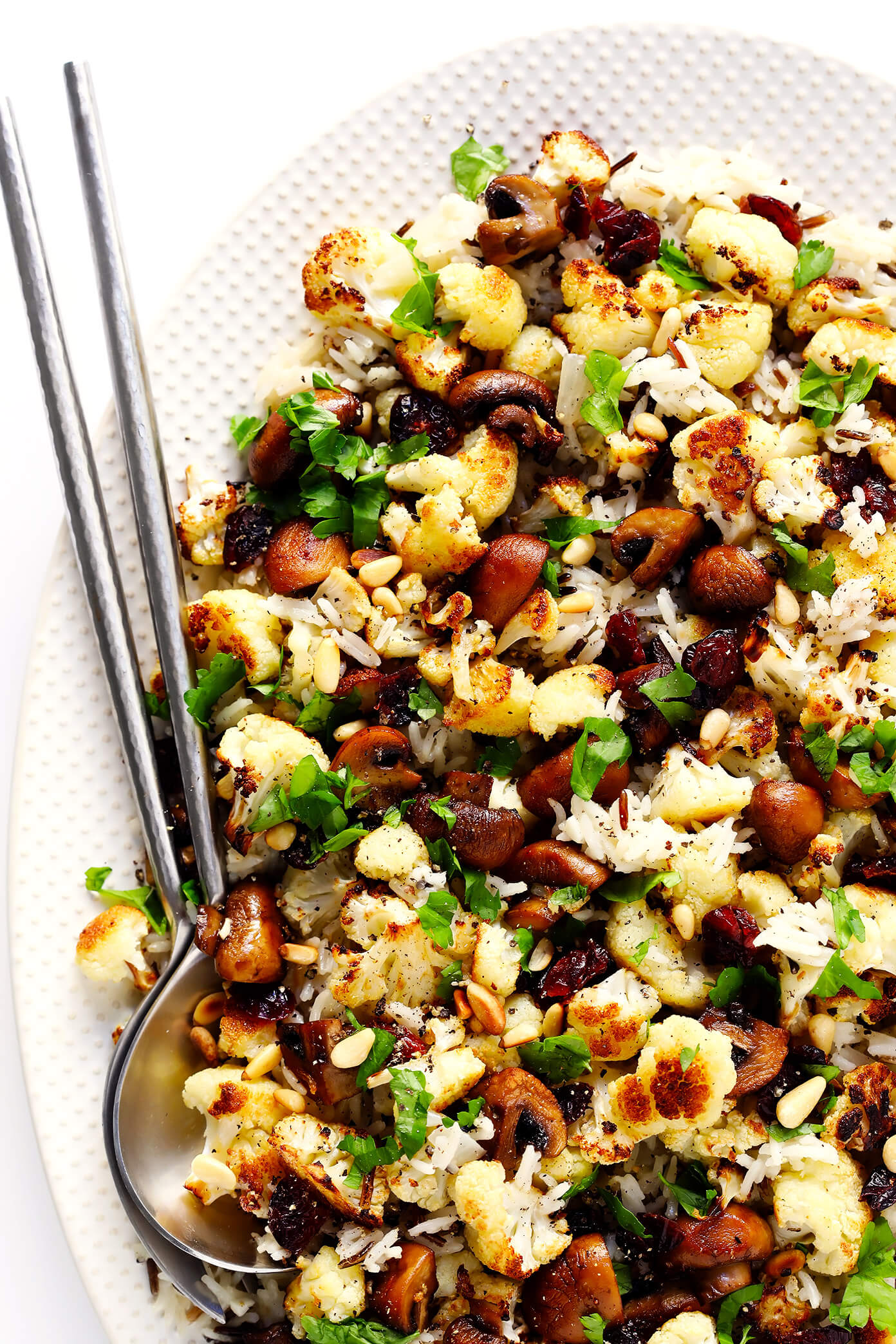 This Roasted Cauliflower, Mushroom and Wild Rice "Stuffing" is the perfect recipe to serve as a Thanksgiving side dish...or as dinner any night of the year! It's naturally gluten-free, vegetarian and vegan. It's made with delicious lemon-garlic rice, dried cranberries, toasted pine nuts, and roasted veggies. And it's AWESOME.