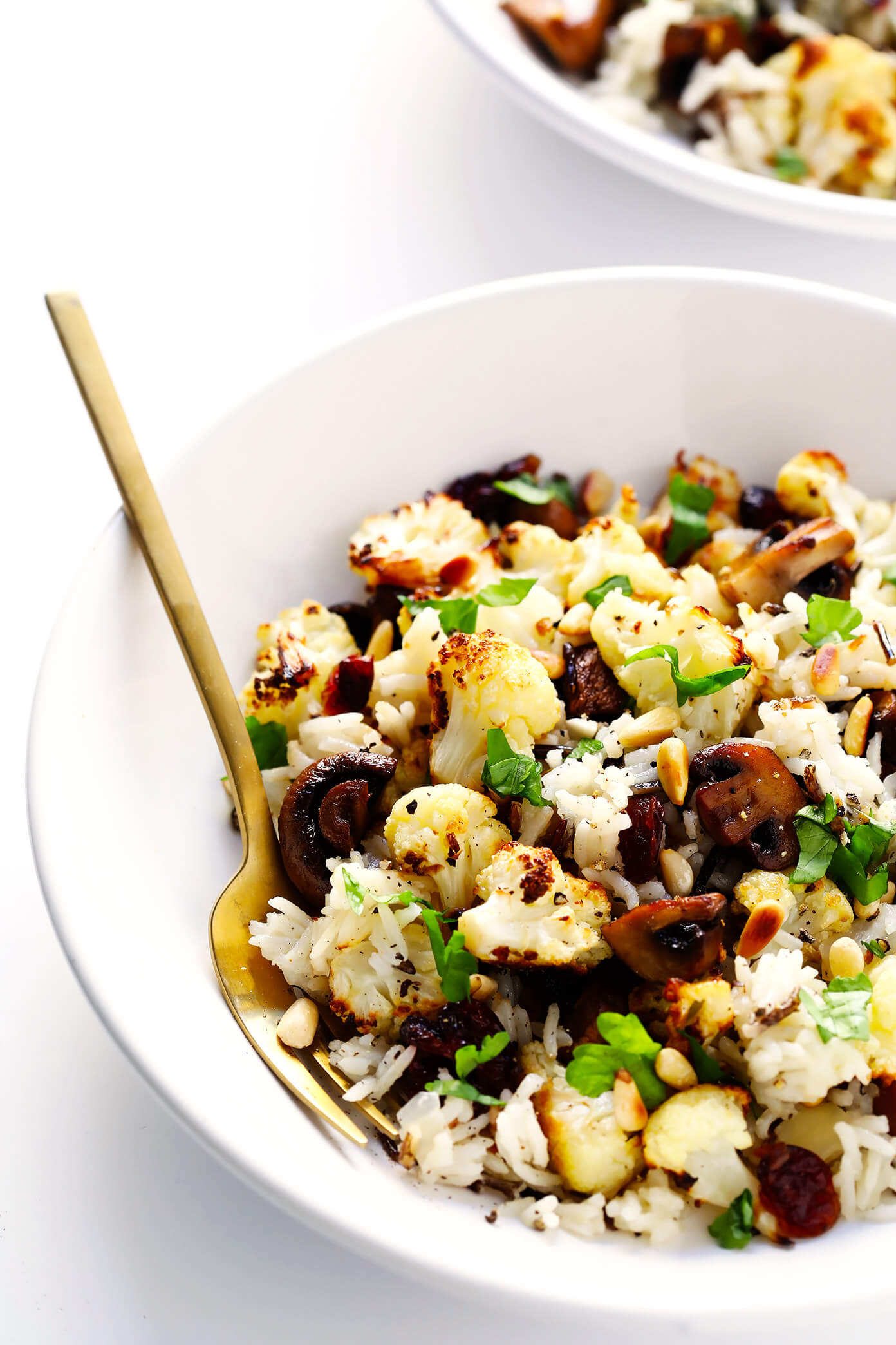 This Roasted Cauliflower, Mushroom and Wild Rice "Stuffing" is the perfect recipe to serve as a Thanksgiving side dish...or as dinner any night of the year! It's naturally gluten-free, vegetarian and vegan. It's made with delicious lemon-garlic rice, dried cranberries, toasted pine nuts, and roasted veggies. And it's AWESOME.