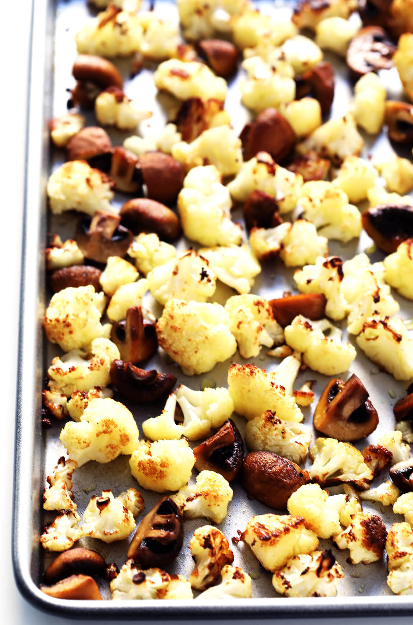 This Roasted Cauliflower, Mushroom and Wild Rice "Stuffing" is the perfect recipe to serve as a Thanksgiving side dish...or as dinner any night of the year! It's naturally gluten-free, vegetarian and vegan. It's made with delicious lemon-garlic rice, dried cranberries, toasted pine nuts, and roasted veggies. And it's AWESOME.